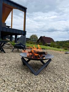 a fire pit sitting on the ground next to a bench at Мої Гори in Pilipets