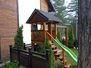 a playground with a gazebo and a green slide at Simic Apartmani Tara in Kaludjerske Bare