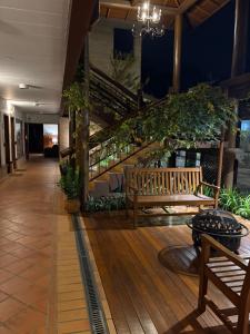 a porch with a bench and stairs in a building at Pousada OAK Plaza in Monte Verde