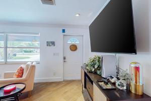 a living room with a large flat screen tv on the wall at Casa Coconut in Naples