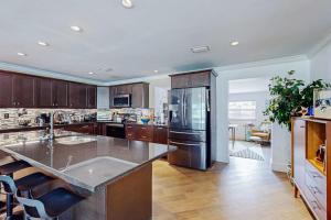 a kitchen with a stainless steel refrigerator and wooden cabinets at Casa Coconut in Naples +17 photos