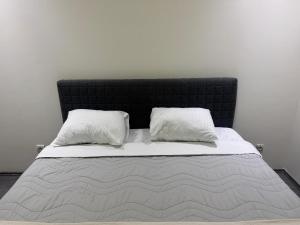 a bed with two pillows on top of it at Ring Inn Apartments in Obrenovac