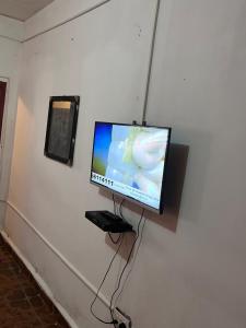 a flat screen tv hanging on a wall at Sumanya guest house 6 in Sukuta