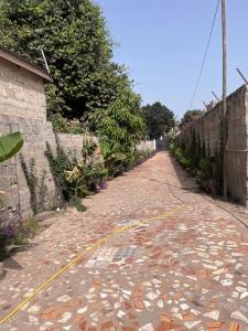 a cobblestone road with a yellow hose on it at Sumanya guest house 6 in Sukuta