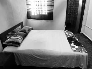 a black and white photo of a bed in a bedroom at Sumanya guest house 6 in Sukuta