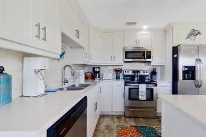 a kitchen with white cabinets and stainless steel appliances at Southwest Florida Sanctuary in Cape Coral