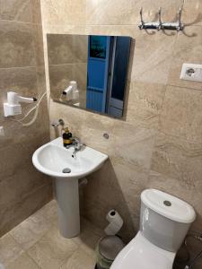 a bathroom with a sink and a toilet and a mirror at Imperio Boge Hotel in Bogë