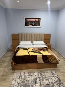 a bedroom with a bed and a painting on the wall at Imperio Boge Hotel in Bogë