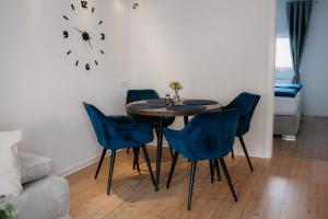 a dining room with a table and blue chairs at Apartment am Berg II in Grünstadt +19 photos