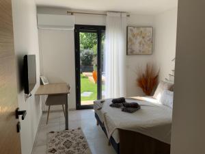 a bedroom with a bed and a desk and a window at Un bon cocon privé climatisé chez l habitant in Valence