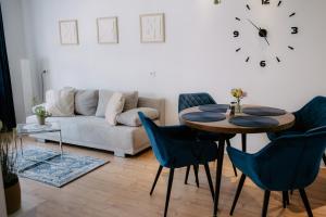 a living room with a table and chairs and a clock at Apartment am Berg II in Grünstadt