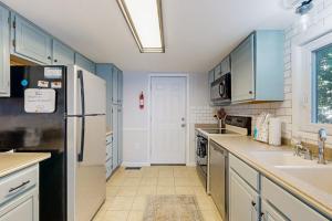 a kitchen with blue cabinets and a black refrigerator at Battersea on the Canal in Ocean Pines +33 photos