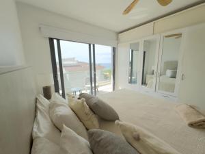 a large white bedroom with a large bed with pillows at Penthouse In Tracadero Oceanfront Infinity Pool in La Laguna +47 photos