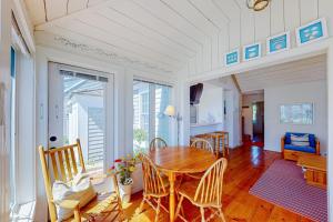a dining room with a wooden table and chairs at Maushop By The Sea in Mashpee