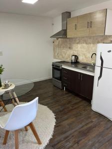a kitchen with a white refrigerator and a table at Monoambiente Lavalle Lujan in Luján