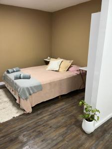 a bedroom with a large bed with wooden floors at Monoambiente Lavalle Lujan in Luján
