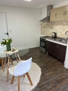 a kitchen with a table and a white chair at Monoambiente Lavalle Lujan in Luján +10 photos