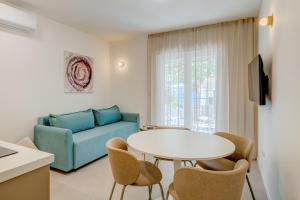 a living room with a couch and a table and chairs at 7 Olives Luxury Suites in Rogoznica