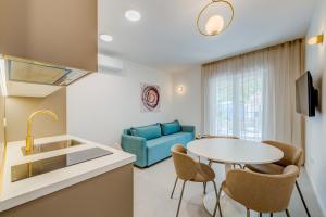 a kitchen and living room with a table and a blue couch at 7 Olives Luxury Suites in Rogoznica +122 photos