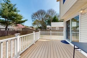 a wooden porch with a white fence on a house at Buttermilk Bliss in Wareham