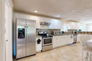 a kitchen with stainless steel appliances and white cabinets at Buttermilk Bliss in Wareham +28 photos