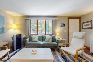 a living room with a couch and two chairs at The Woodland Cottage in Eastham