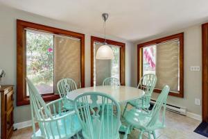 a dining room with a blue table and chairs at The Woodland Cottage in Eastham