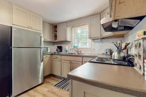 a kitchen with a stainless steel refrigerator and cabinets at The Woodland Cottage in Eastham