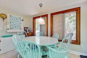 a dining room with a white table and chairs at The Woodland Cottage in Eastham