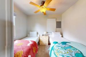 a bedroom with two beds and a ceiling fan at Green Cottage Getaway in Frankfort +6 photos