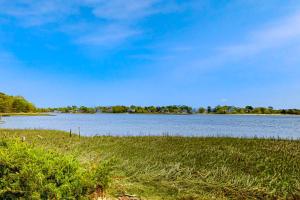 a view of a large body of water with grass at Sunset Cove Retreat in Wareham