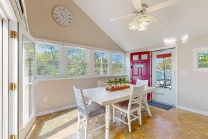 a dining room with a table and chairs and a clock at Sunset Cove Retreat in Wareham +27 photos