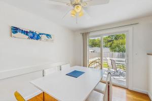 a white dining room with a white table and chairs at Great Pond Escape in Falmouth