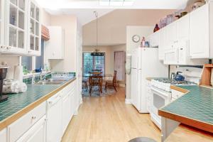 a kitchen with white cabinets and green counter tops at Beaconhill Road 68 in Ocean Pines