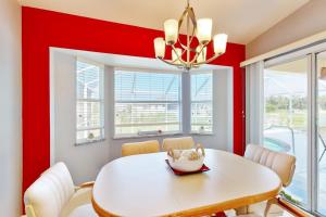 a dining room with red walls and a white table and chairs at Sunny Way in Rotunda-West