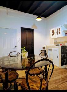 a glass table and chairs in a room with a kitchen at Villa San Valentin in San Pedro Sula