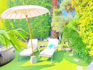 a group of chairs and an umbrella in a garden at O jardin des Sens -Séjour Bien-être & détente &Jacuzzi in Béziers