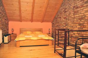 een slaapkamer met een bed en een bakstenen muur bij Guest house Pikec in Bezdan