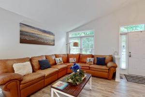 a living room with a brown couch and a table at Coral Shells in Ocean Pines