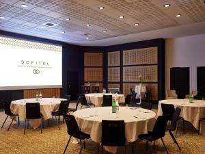 a conference room with tables and chairs and a screen at Sofitel Biarritz Le Miramar Thalassa in Biarritz +143 photos