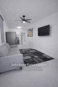 a living room with a couch and a flat screen tv at Modern Private Stay in Fajardo, PR - NEAR FERRY - BEACHES - EL YUNQUE - BIO BAY in Fajardo