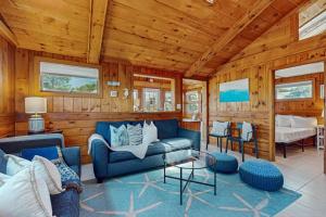 a living room with a blue couch and wooden walls at Glendon Beach Getaway in Dennis