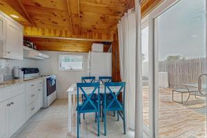 a kitchen with blue chairs and a table in a kitchen at Glendon Beach Getaway in Dennis