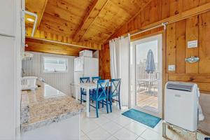 a kitchen with a table and blue chairs in a room at Glendon Beach Getaway in Dennis