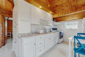 a kitchen with white cabinets and a wooden ceiling at Glendon Beach Getaway in Dennis