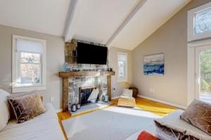 a living room with a fireplace and a flat screen tv at Seabury Serenity in New Seabury