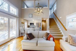 a living room with a couch and a staircase at Seabury Serenity in New Seabury