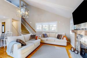 a living room with a white couch and a fireplace at Seabury Serenity in New Seabury