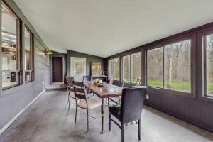 a dining room with a table and chairs and windows at La Casa Chikaming in Union Pier