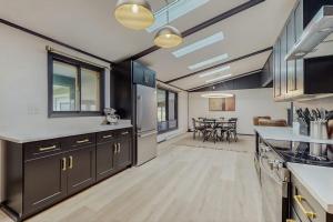 a kitchen with black cabinets and a dining room at La Casa Chikaming in Union Pier +20 photos